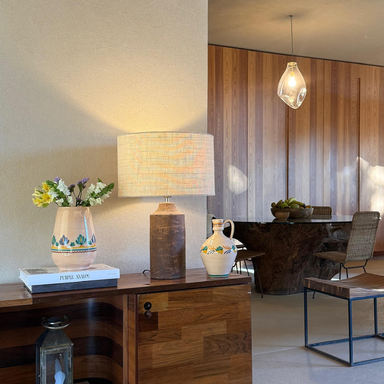 Modern interior with wooden sideboard, lamp, and chairs.