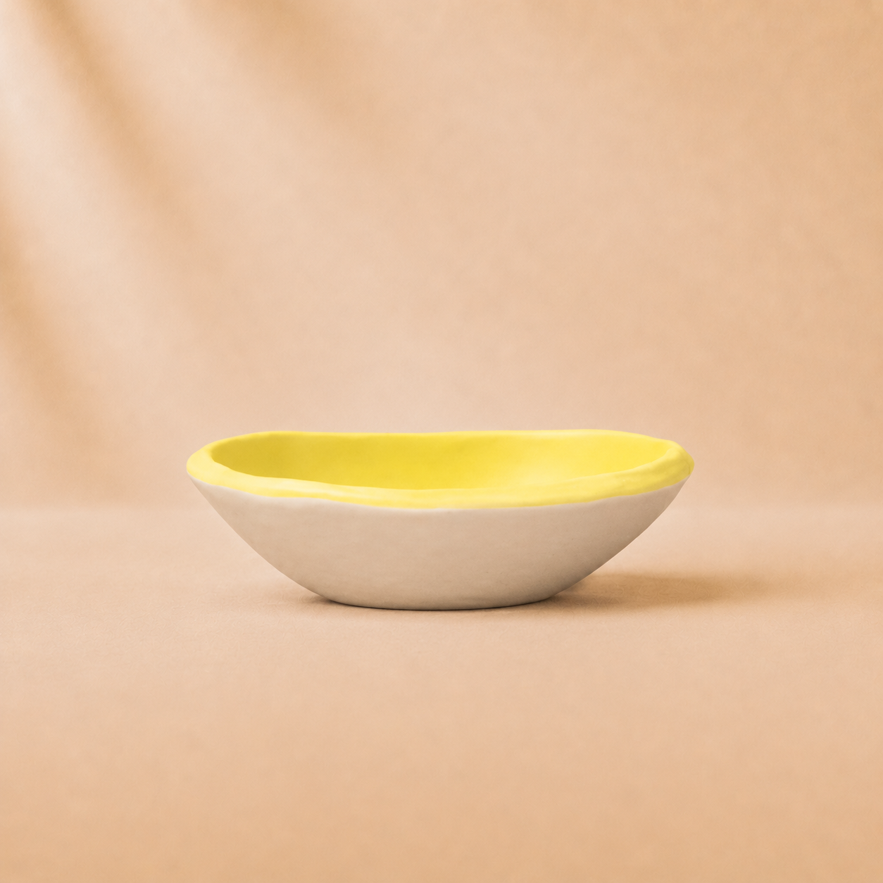 Yellow and white ceramic bowl on a beige background