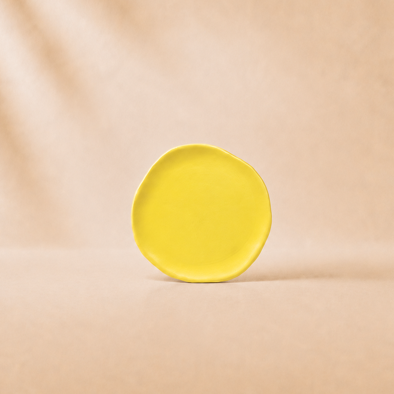 Yellow ceramic plate on a beige background