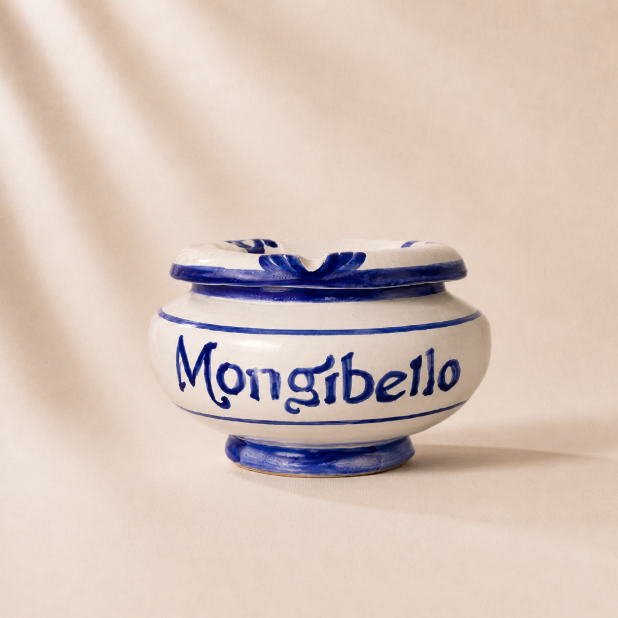 Ceramic jar with blue accents and 'Mongibello' branding on a beige background