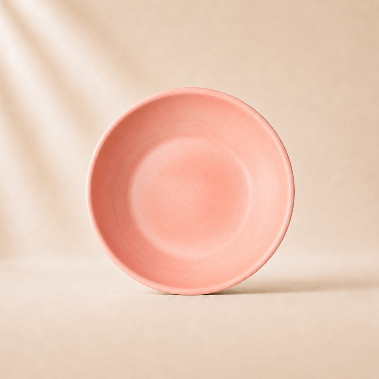 Coral ceramic monochrome pasta bowl on a beige background