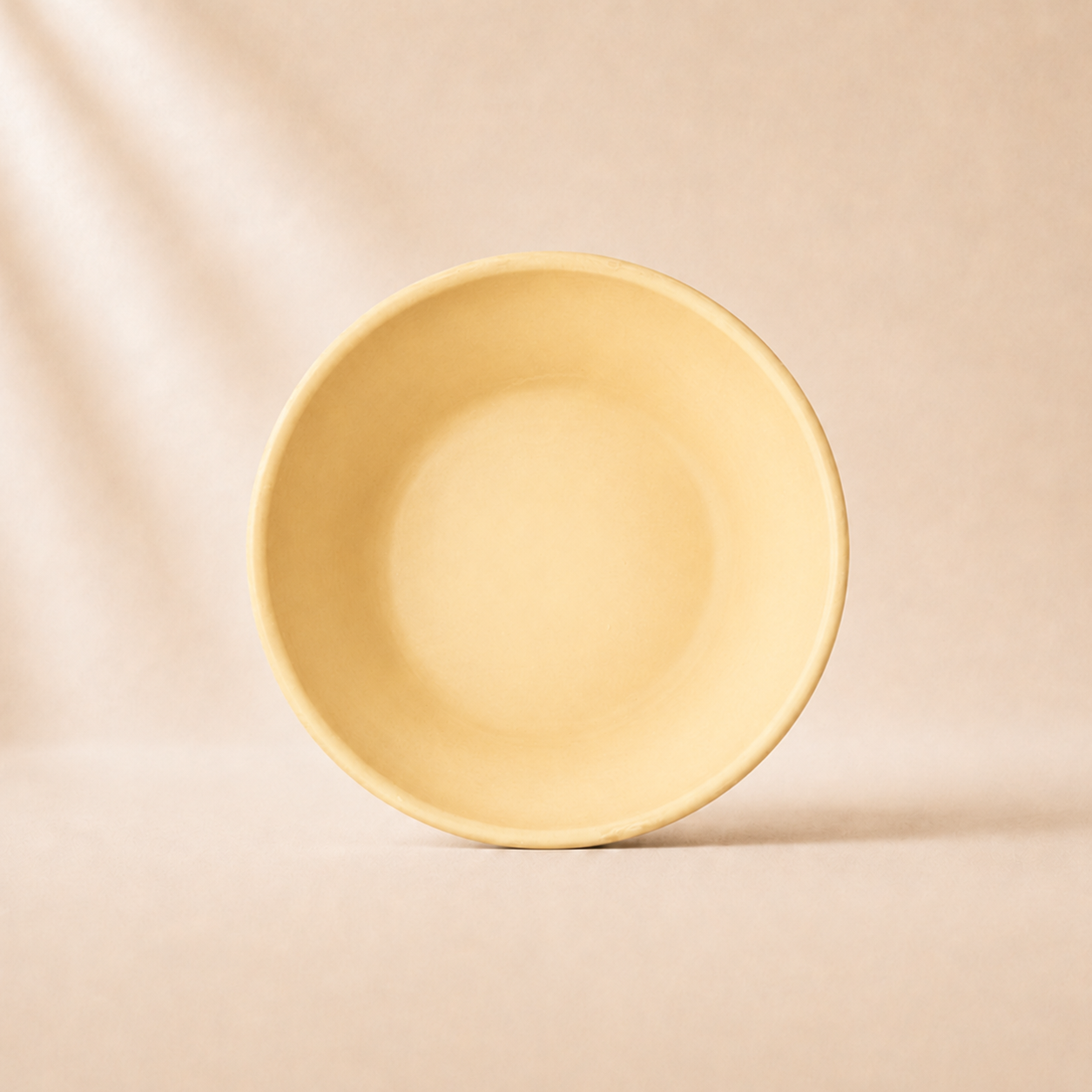 Peach monochrome ceramic pasta bowl on a beige background