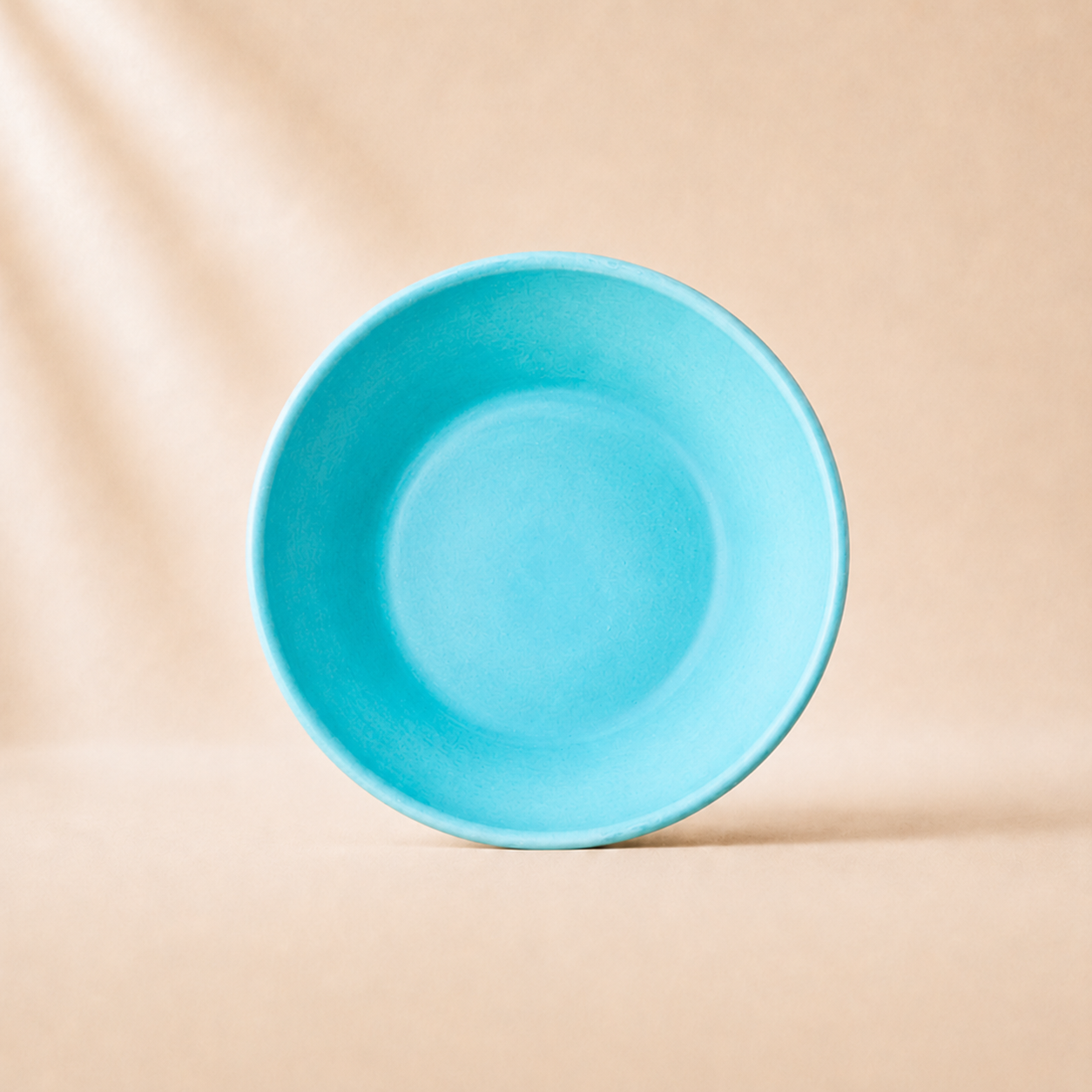 Turquoise monochrome ceramic pasta  bowl on a beige background
