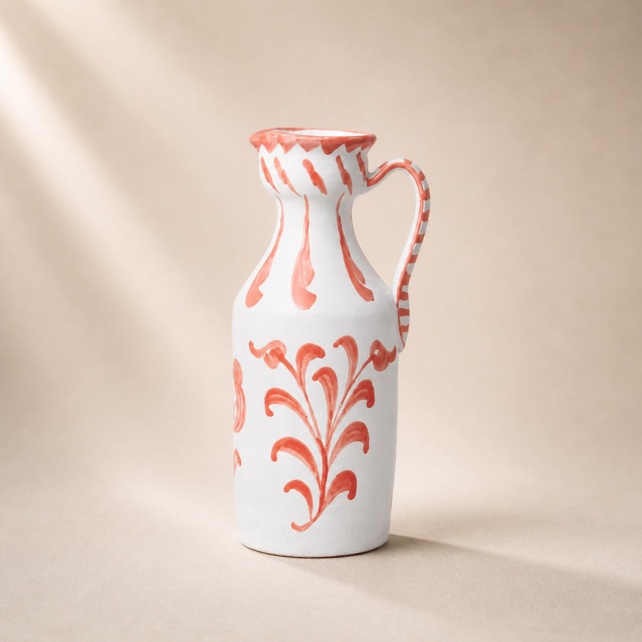 White ceramic vase with red floral patterns on a beige background