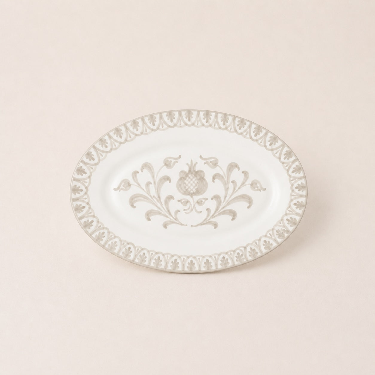 Decorative white plate with intricate gold patterns on a beige background