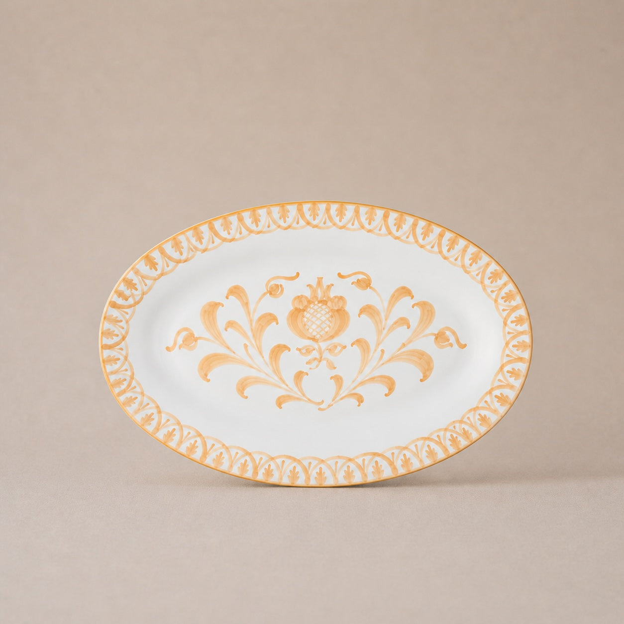 Decorative plate with gold floral design on a beige background