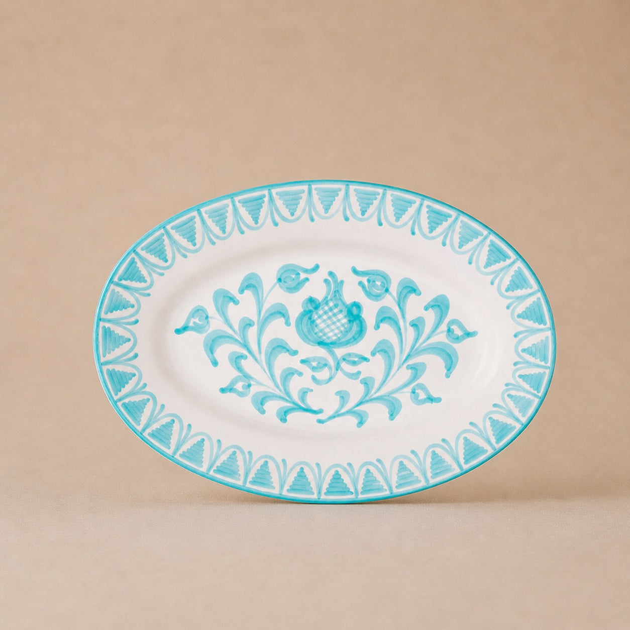 Decorative plate with blue floral design on a beige background