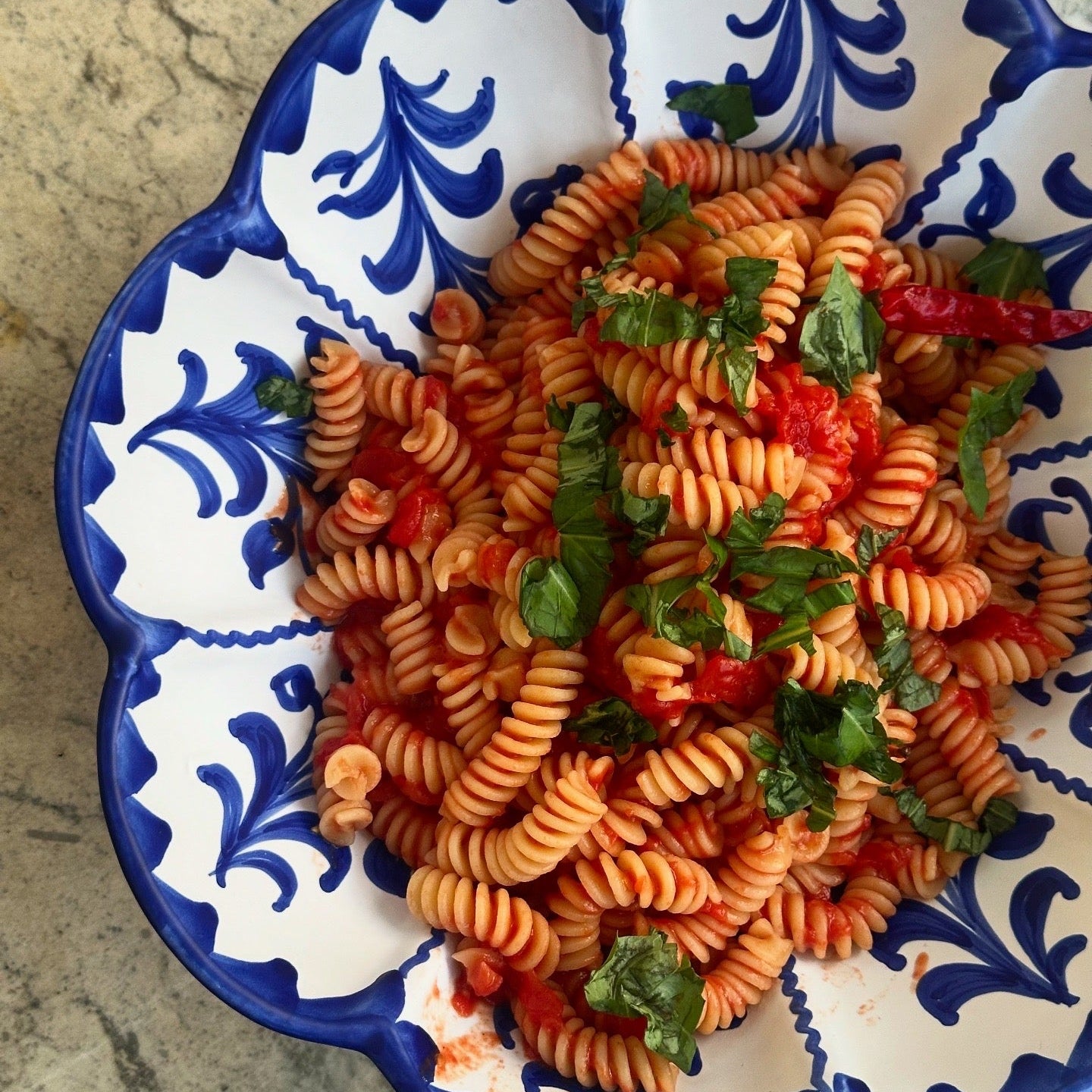 Pasta dish with vegetables in a decorative blue and white bowl - lifestyle