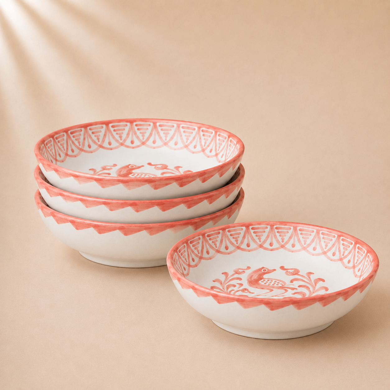 Set of white bowls with red decorative rims on a beige background