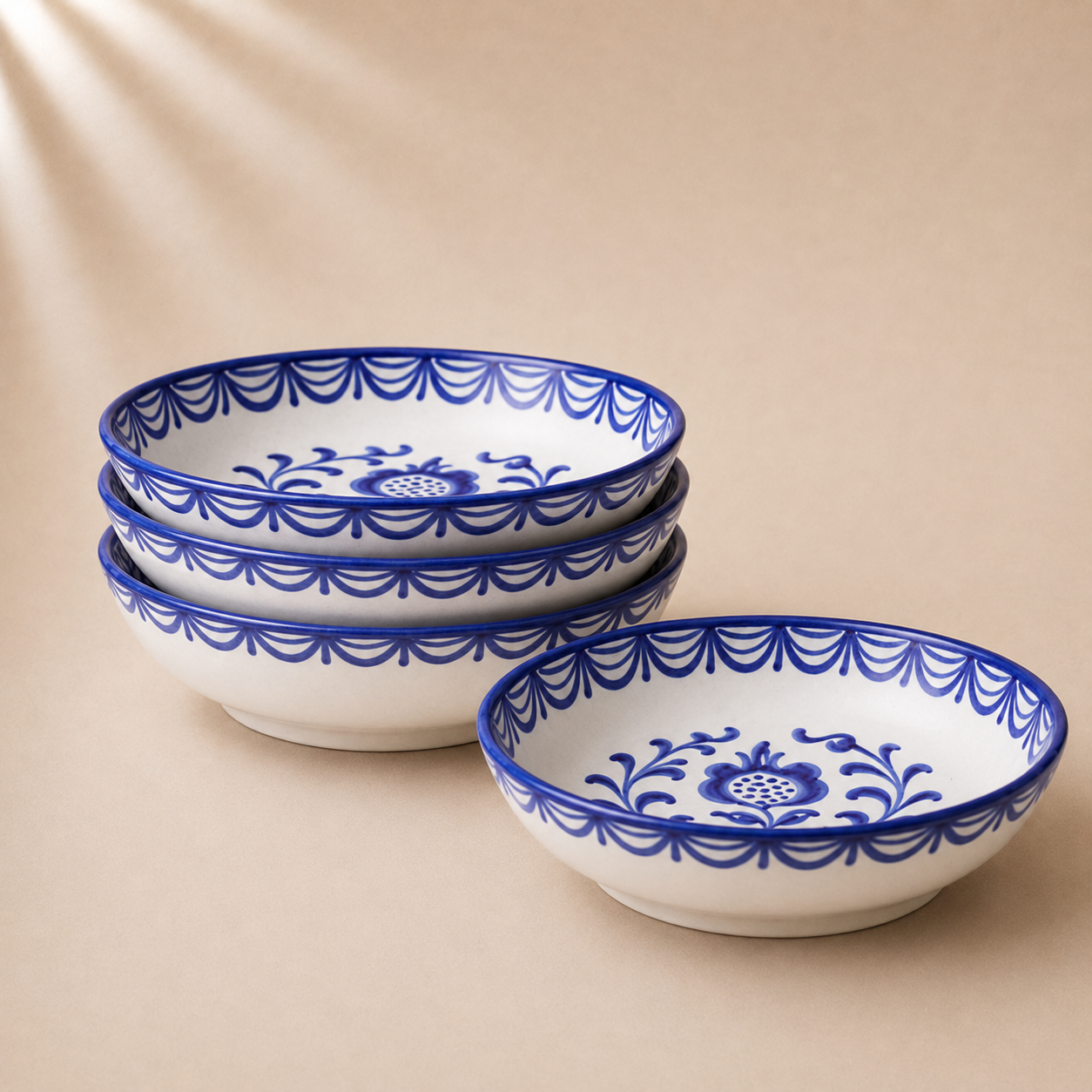 Set of four ceramic bowls with blue floral patterns on a beige background