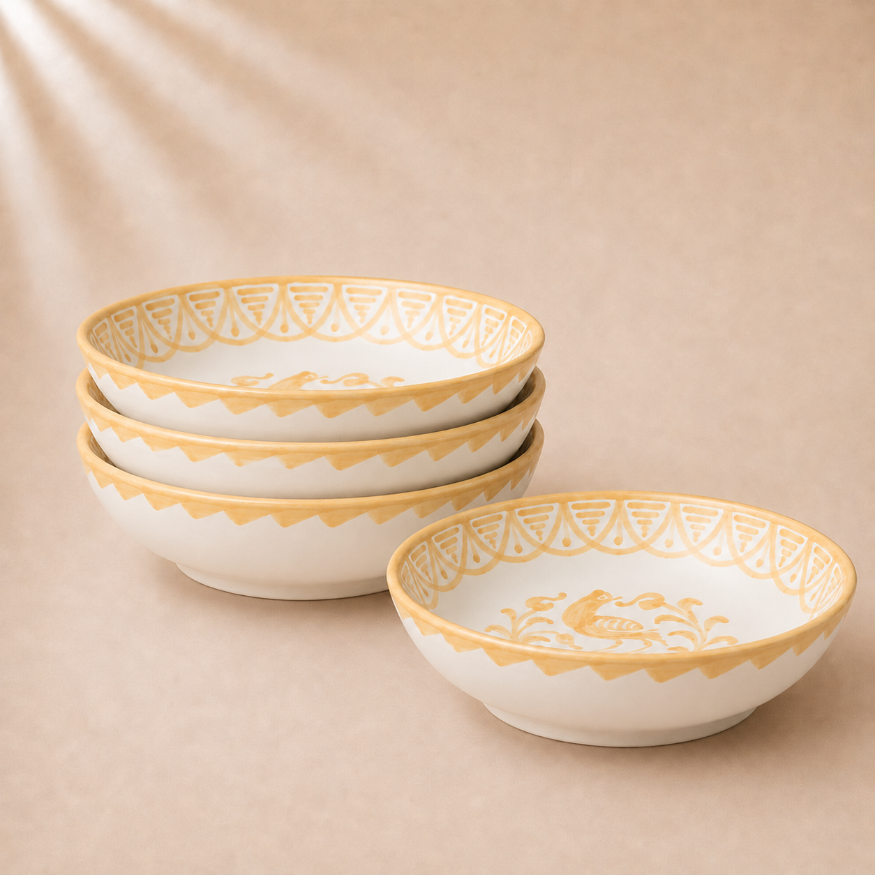 Set of ceramic bowls with gold decorative rims on a beige background