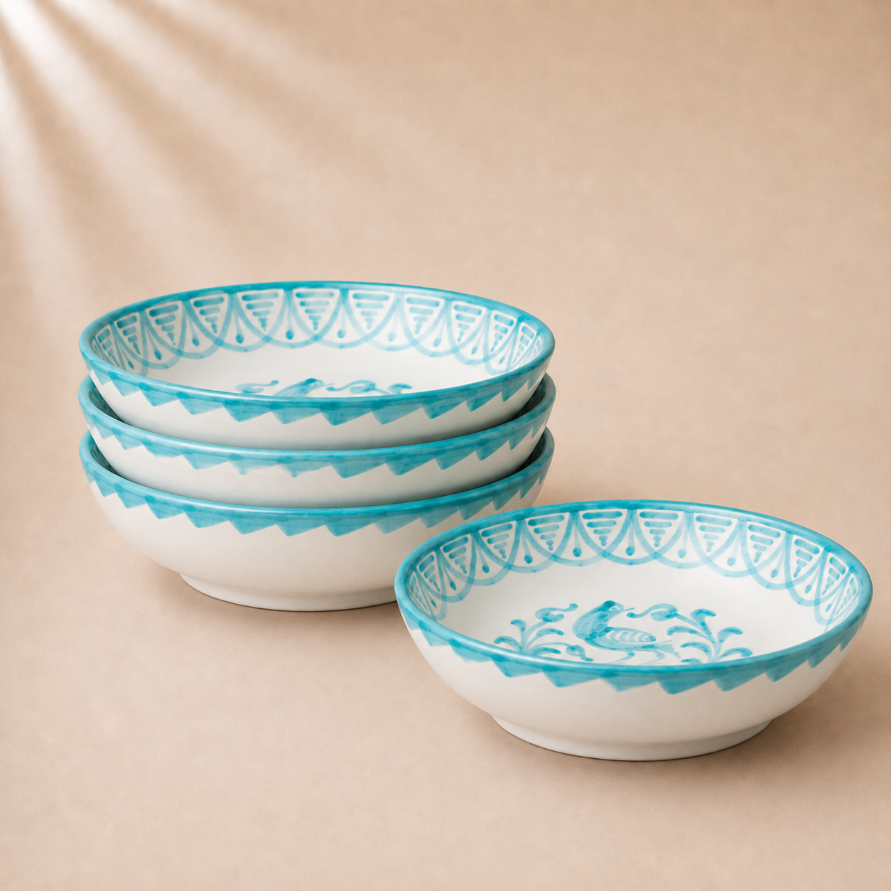 Set of four ceramic bowls with blue decorative patterns on a beige background