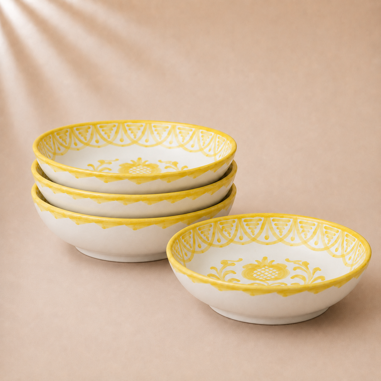 Set of four ceramic bowls with yellow decorative rims on a beige background