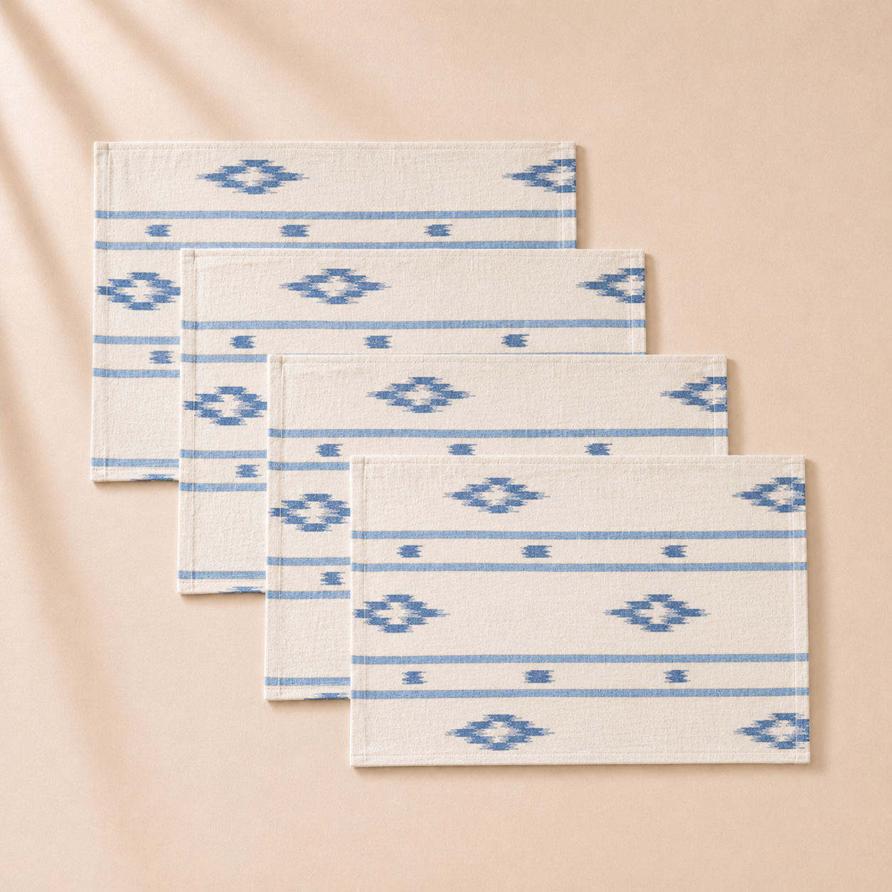 Set of four rectangular mats with blue geometric patterns on a beige background