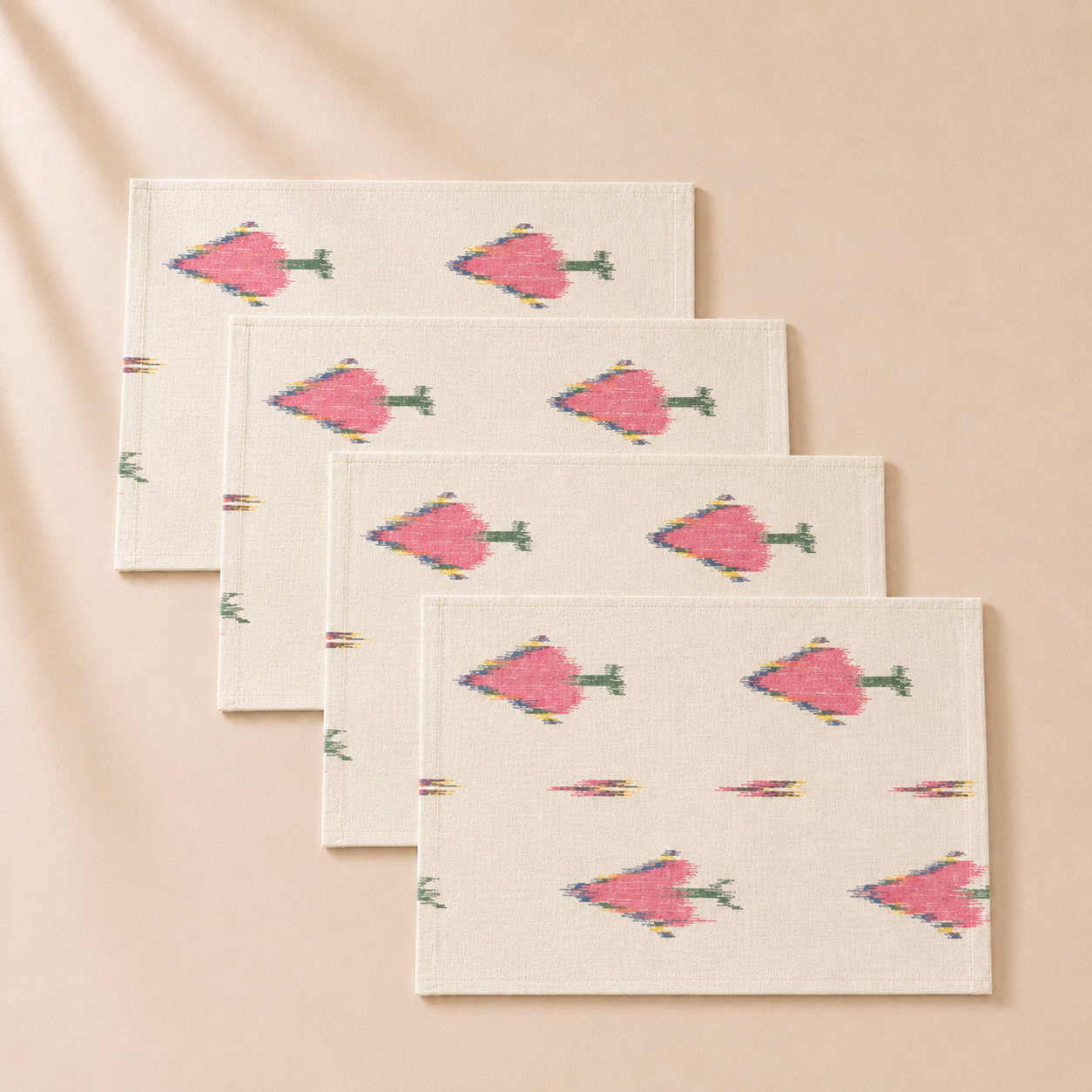 Set of four folded napkins with pink floral patterns on a beige background