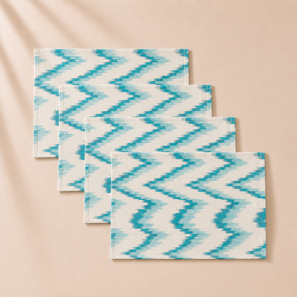 Three blue and white zigzag patterned placemats on a beige background