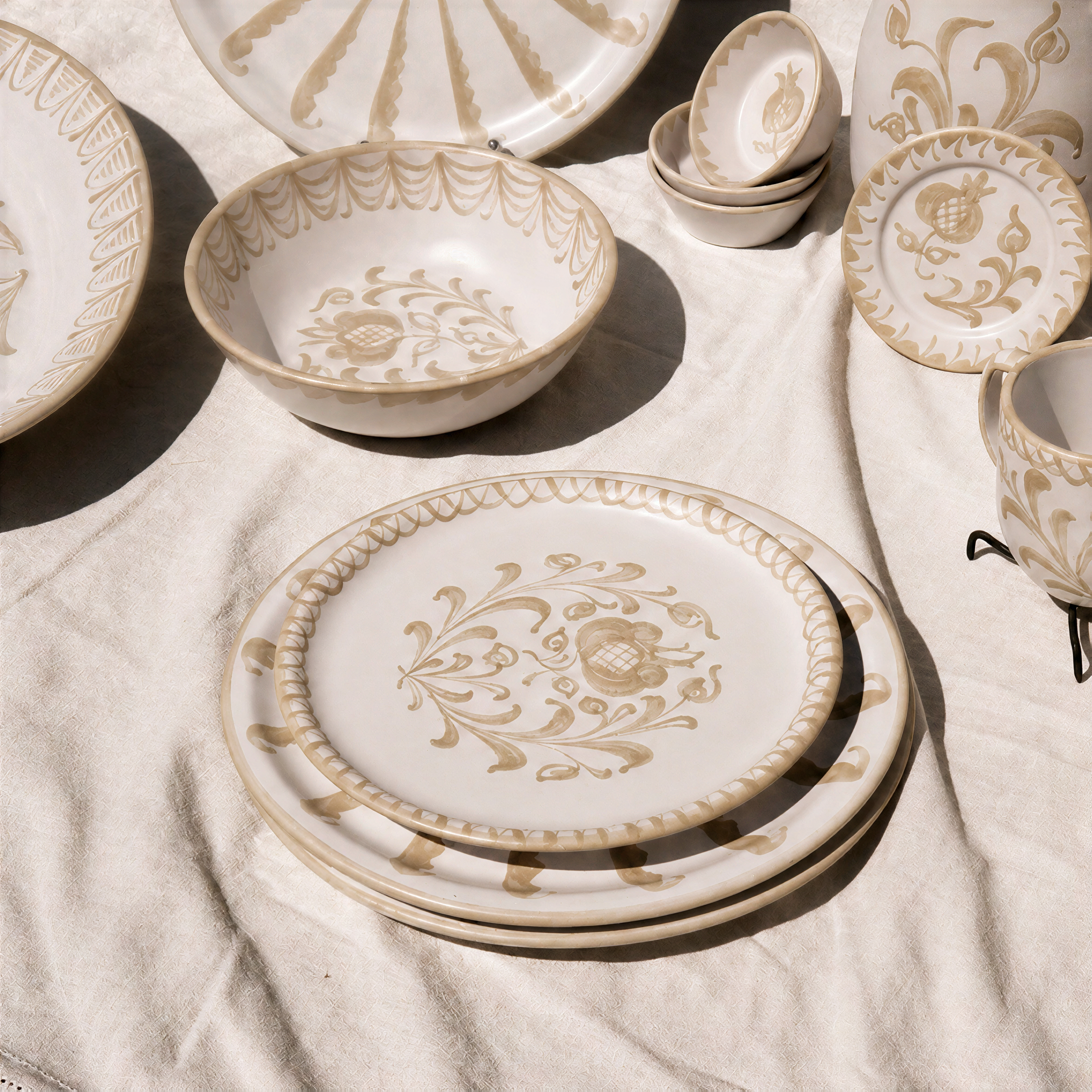 A round ceramic plate with a cream base and a dark blue marbled abstract pattern, styled on a gray tablecloth with silver cutlery and a patterned napkin. - lifestyle