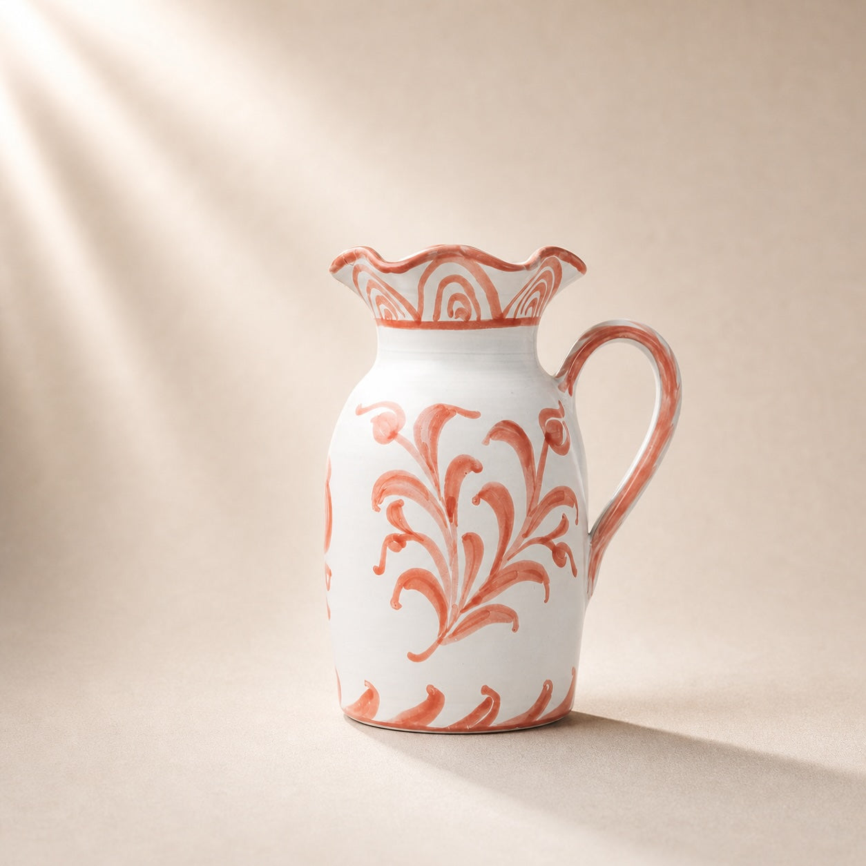 Ceramic pitcher with floral pattern on a beige background
