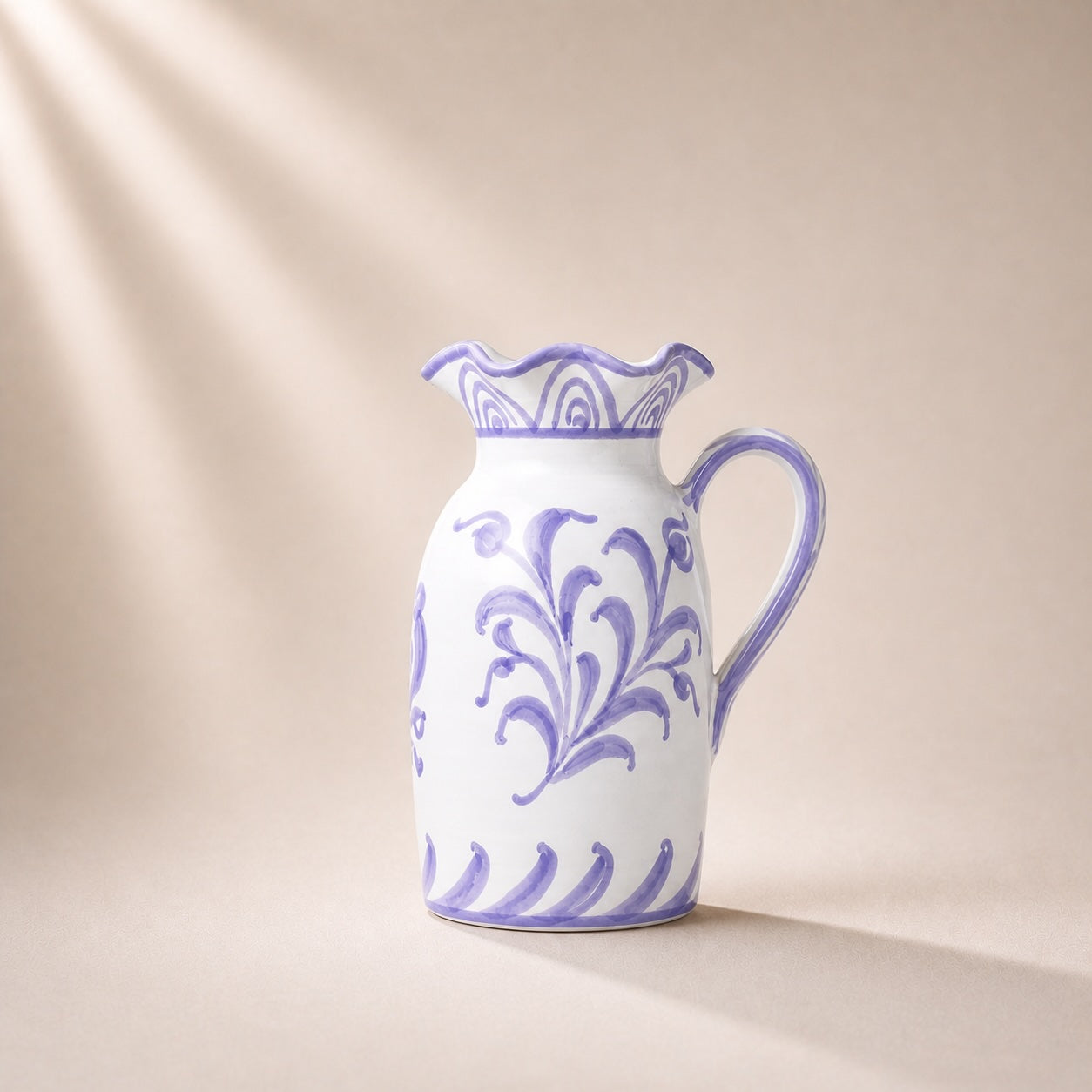 White ceramic pitcher with purple floral patterns on a beige background