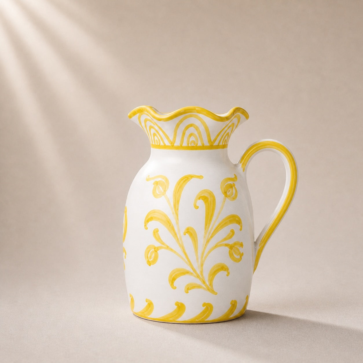 White ceramic pitcher with yellow floral patterns on a beige background