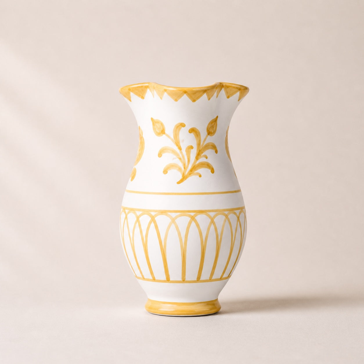 White vase with gold decorative patterns on a beige background