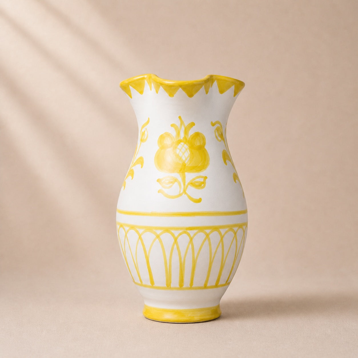 White vase with yellow floral patterns on a beige background