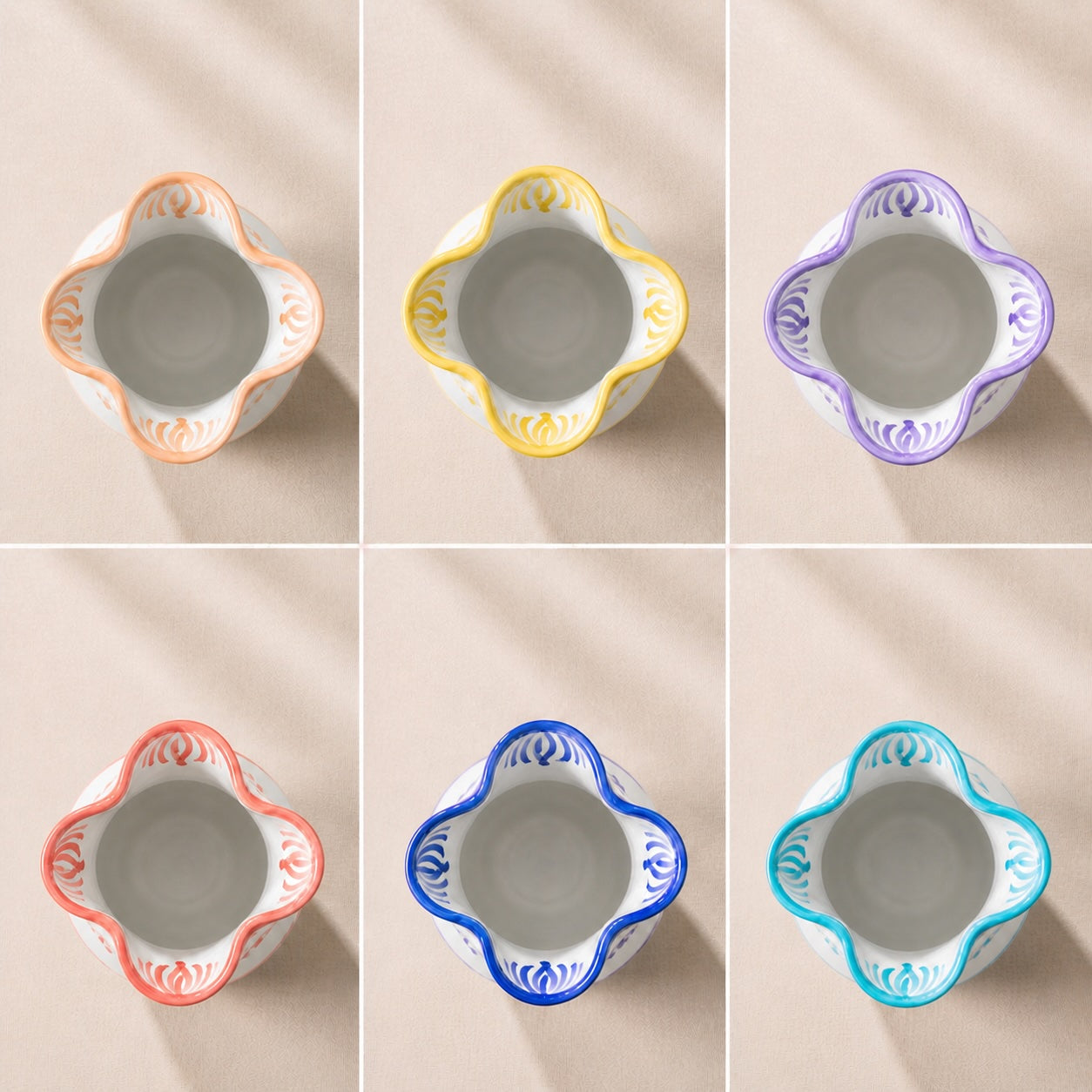Set of six ceramic bowls with colorful decorative rims on a beige background