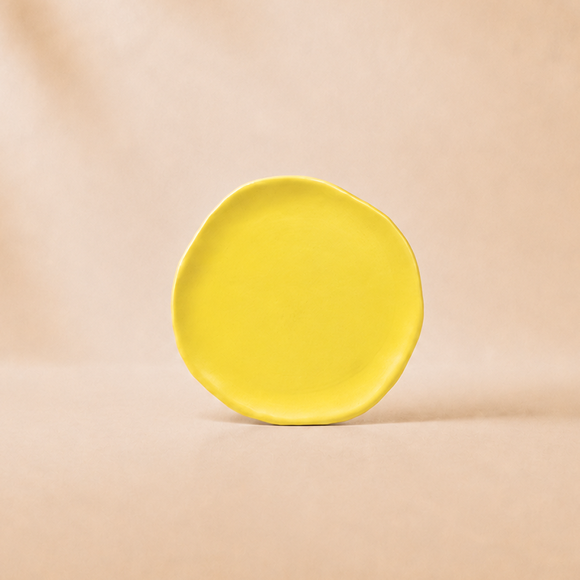 Yellow ceramic plate on a beige background