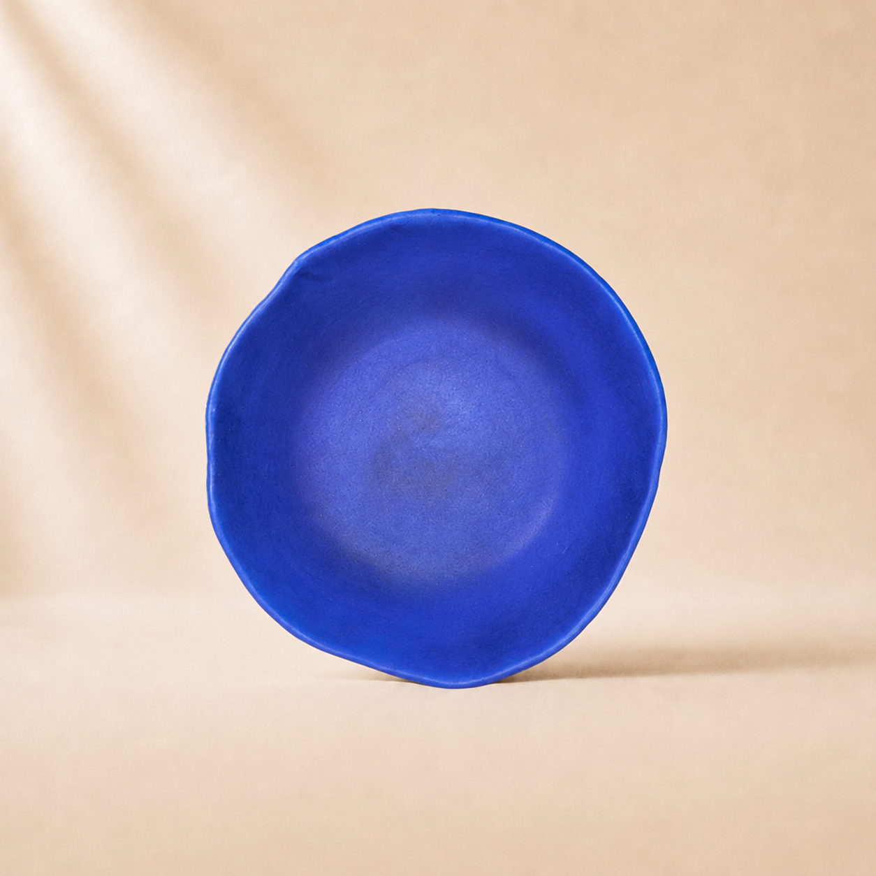 Blue ceramic bowl on a beige background