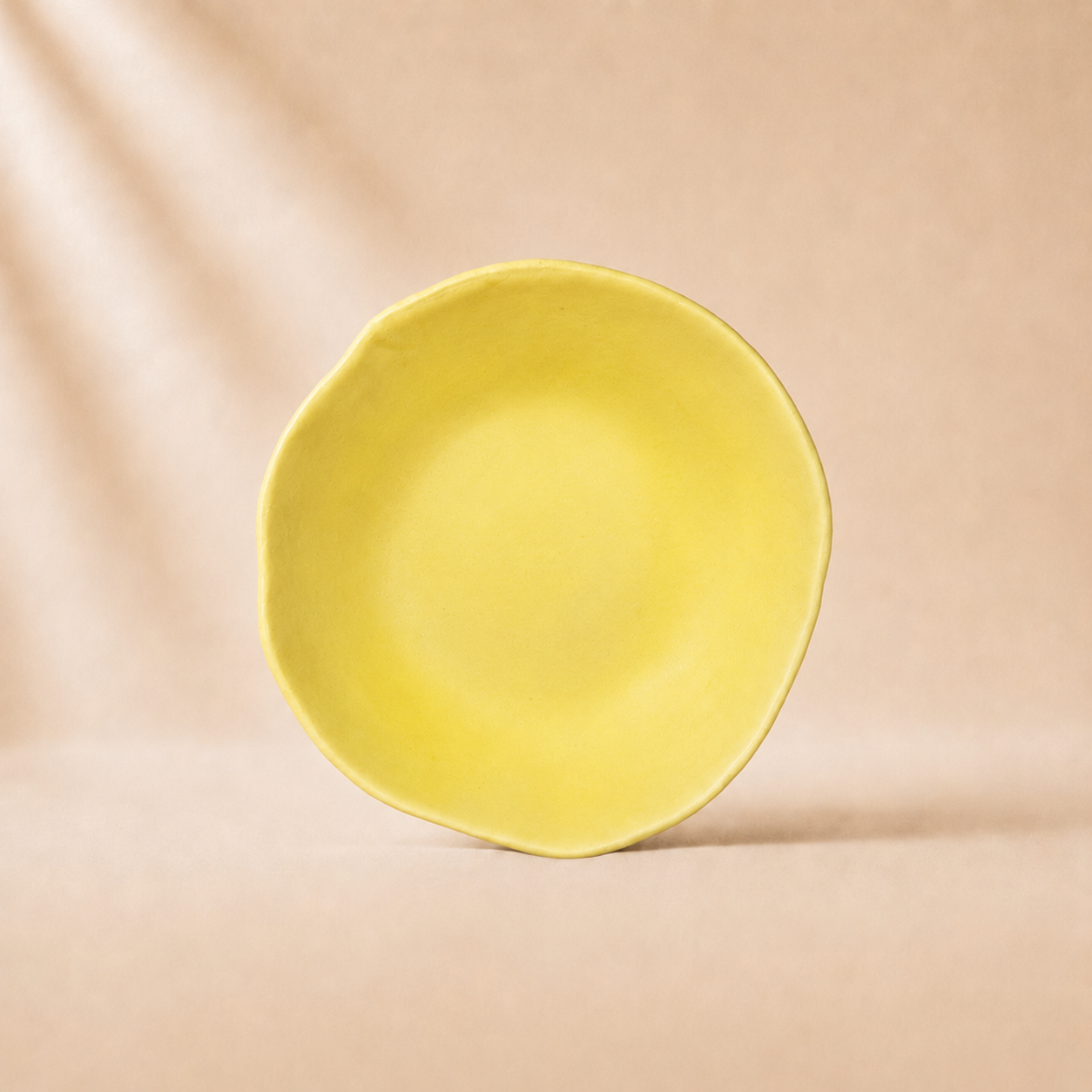 Yellow ceramic bowl on a beige background