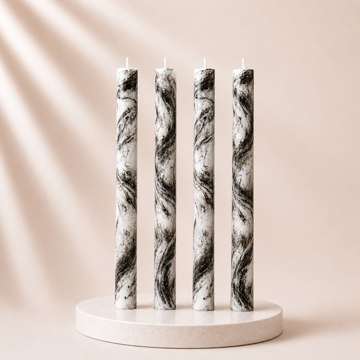 Four marble-patterned candles on a white stand against a beige background