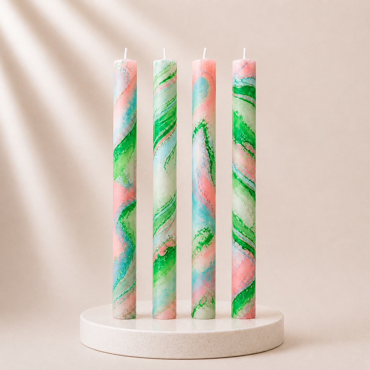 Four multicolored candles on a white stand against a beige background