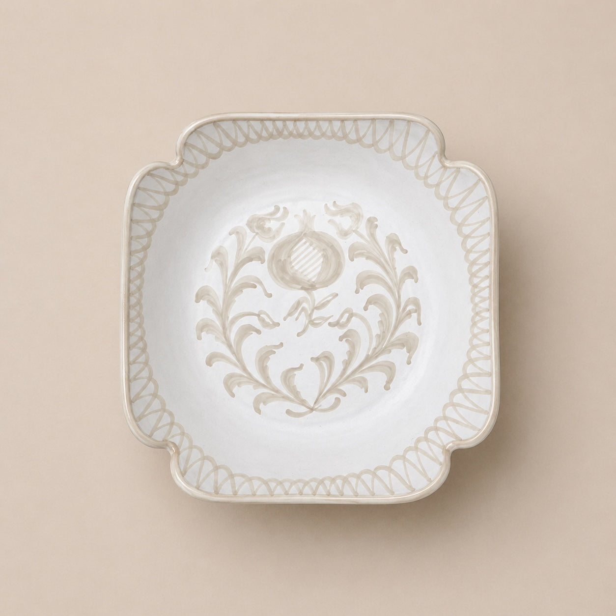 Decorative white plate with intricate patterns on a beige background