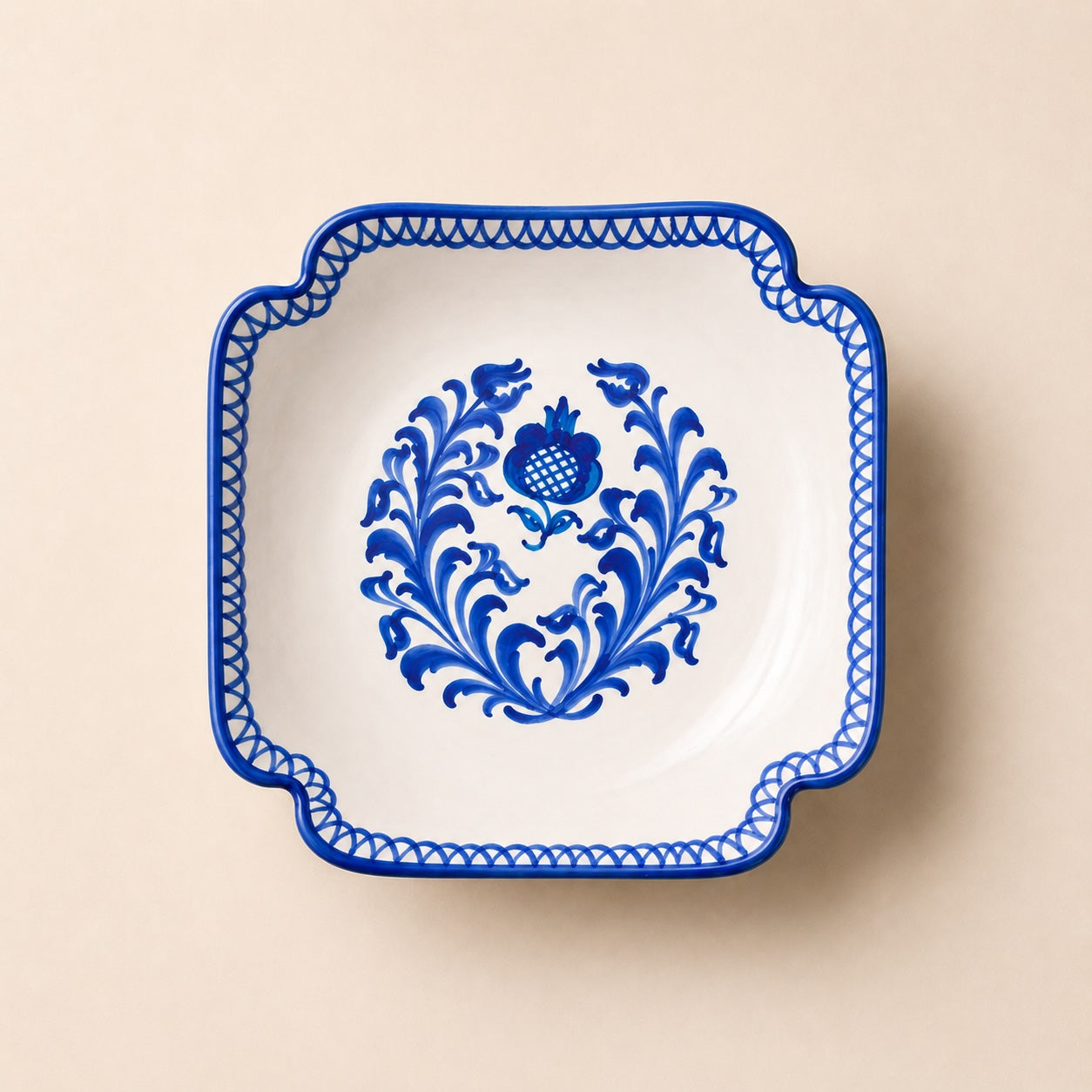 Square plate with blue floral design on a beige background