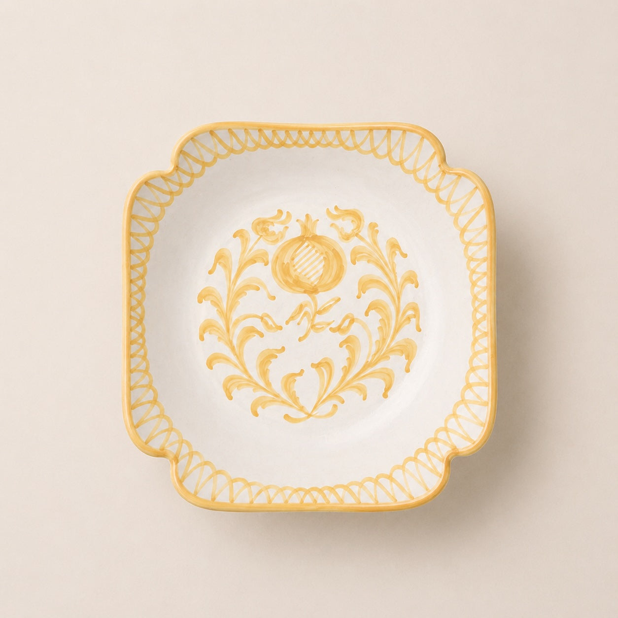 Decorative plate with gold floral design on a beige background