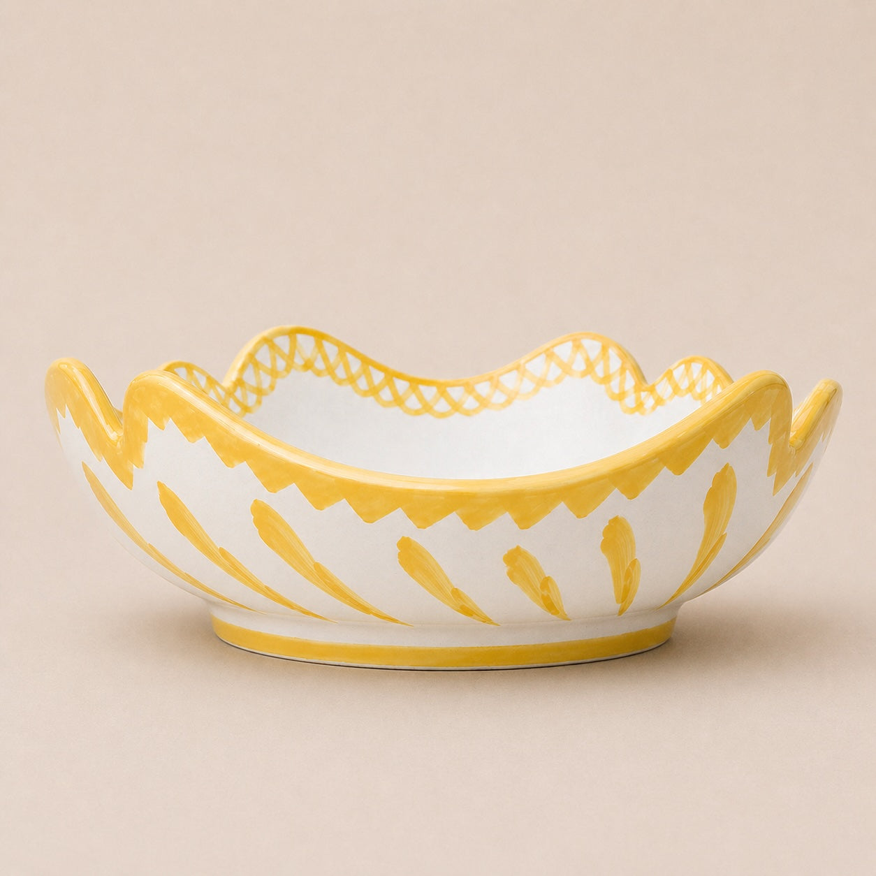 Decorative ceramic bowl with yellow and white pattern on a beige background