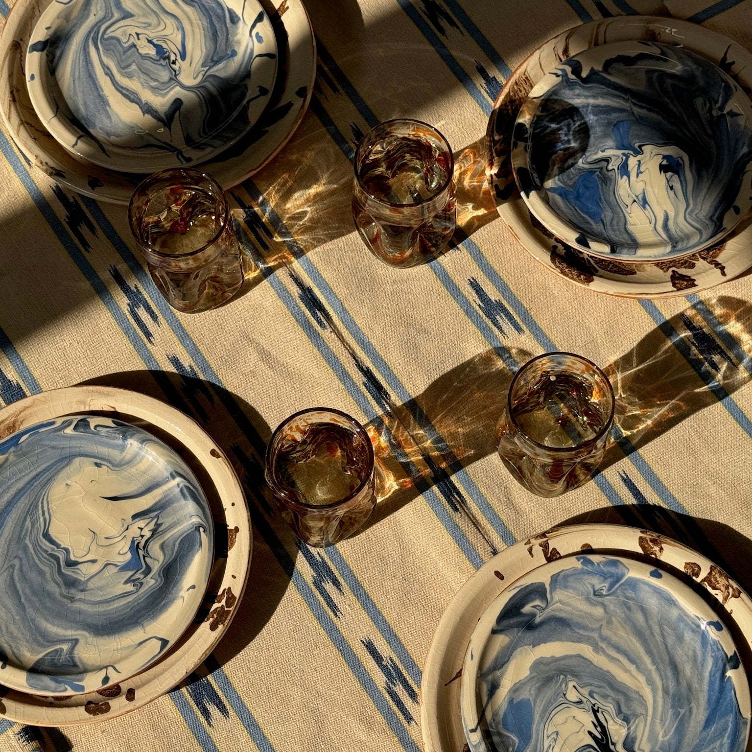 Decorative ceramic plates with blue and white marbled design on a striped surface
