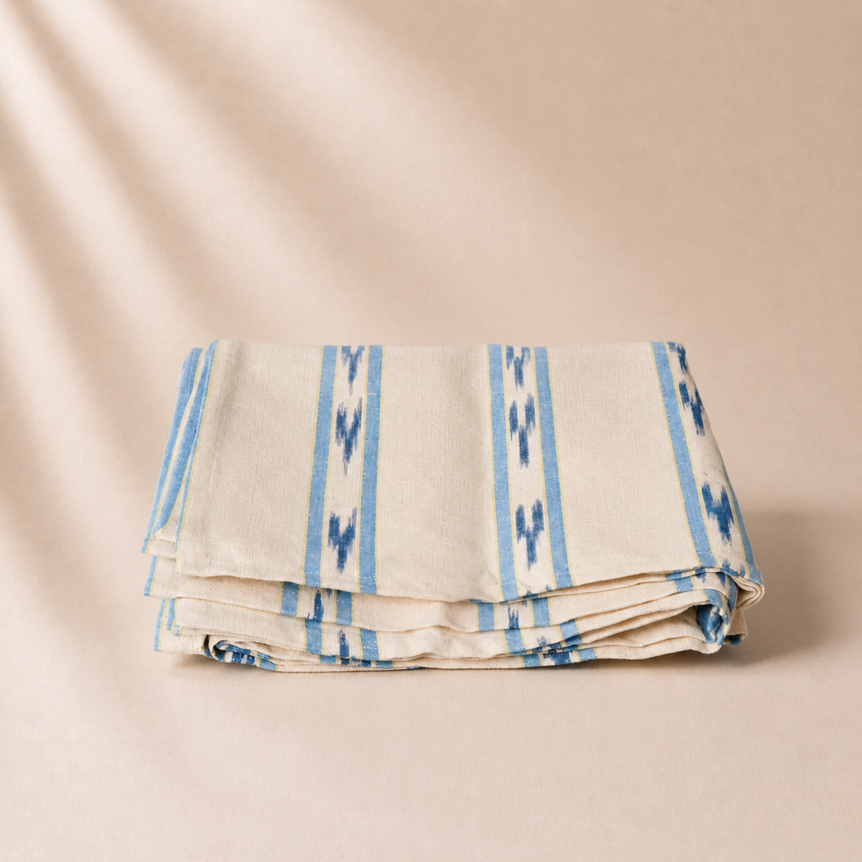 Folded fabric with blue patterns on a beige background