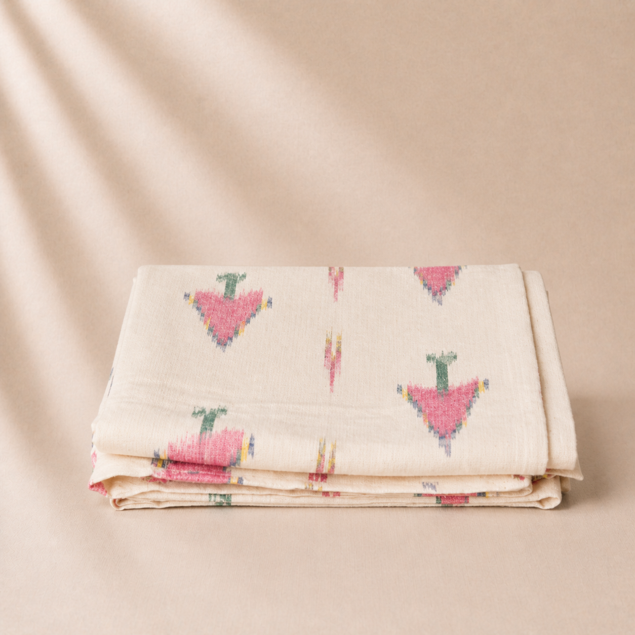 Folded fabric with colorful geometric pattern on a beige background