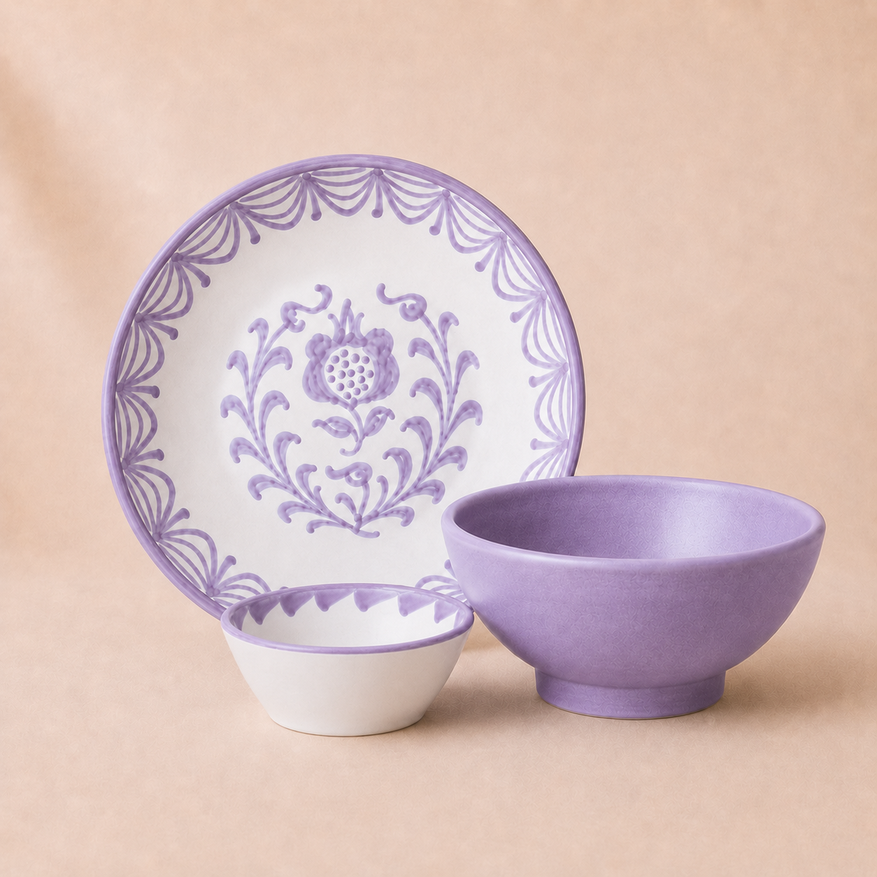 Ceramic plate, bowl, and small dish with purple floral patterns on a beige background