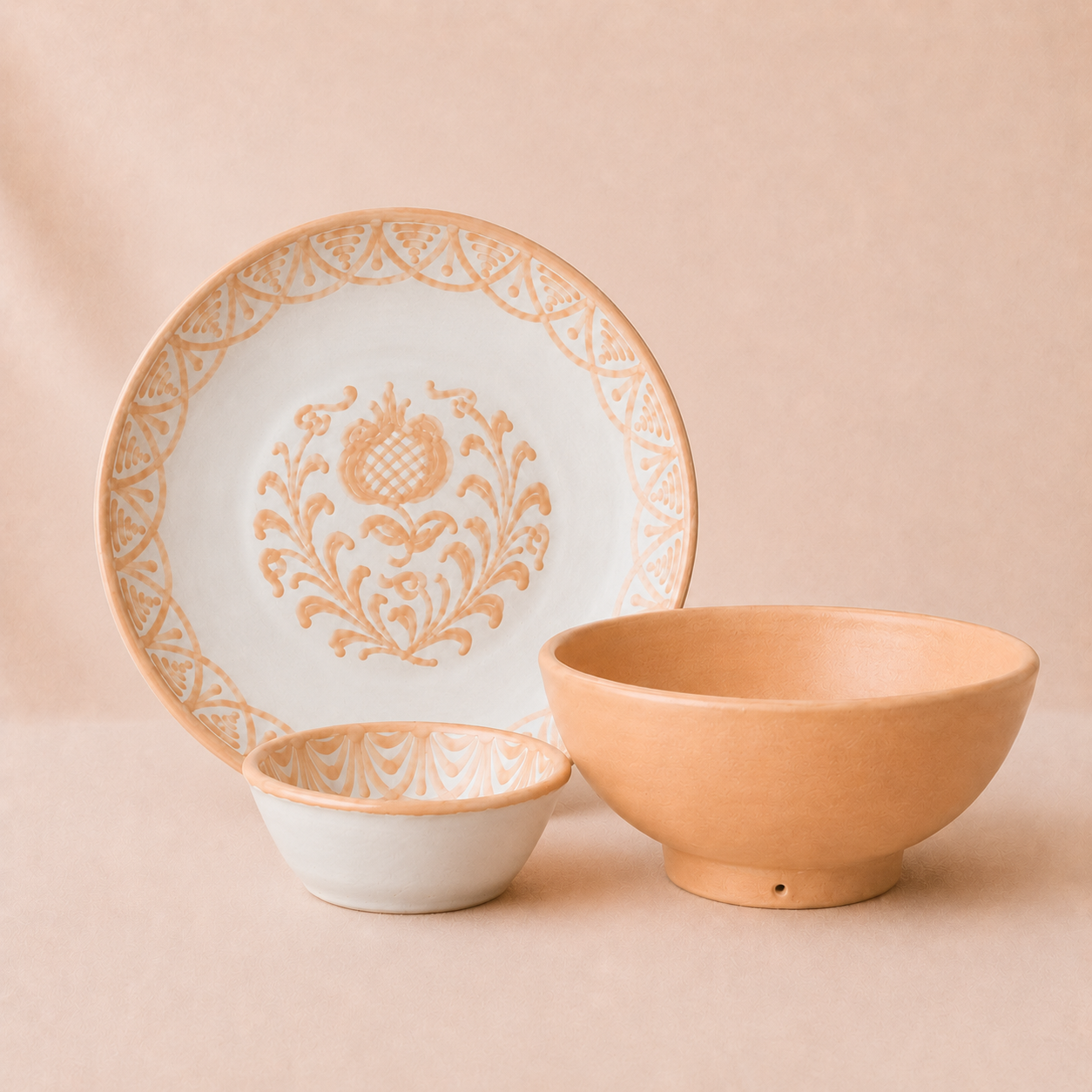 Ceramic plate with decorative floral pattern and two bowls on a beige background