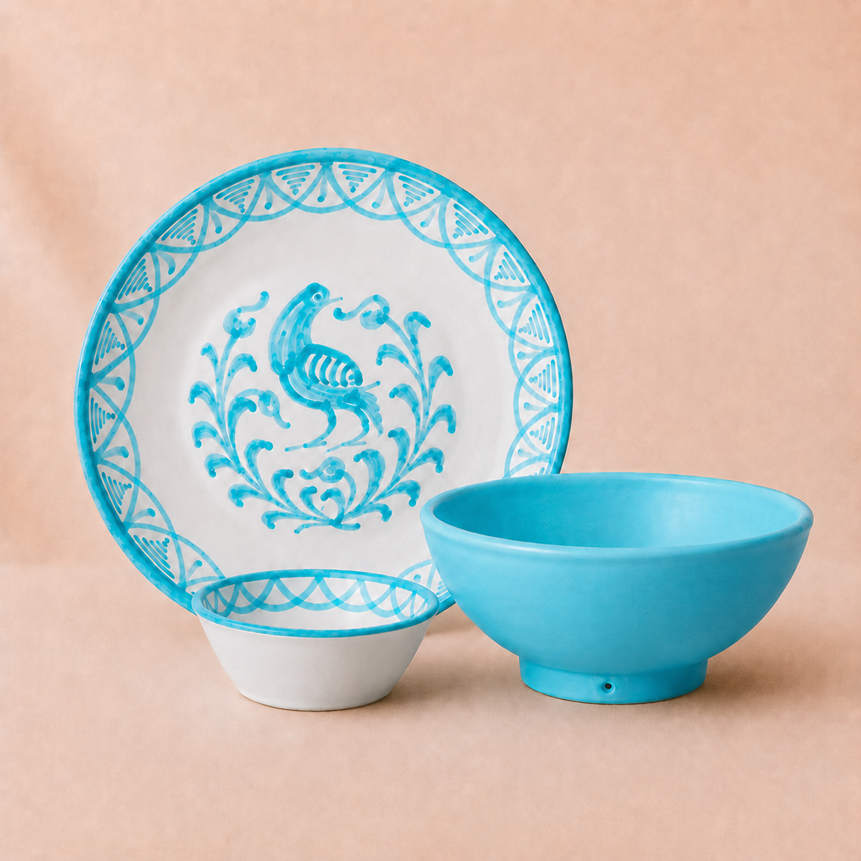 Blue and white ceramic plate with decorative rooster design next to a blue bowl on a beige background