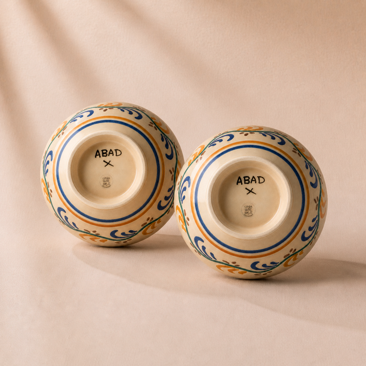 Two ceramic jars with decorative patterns on a beige background