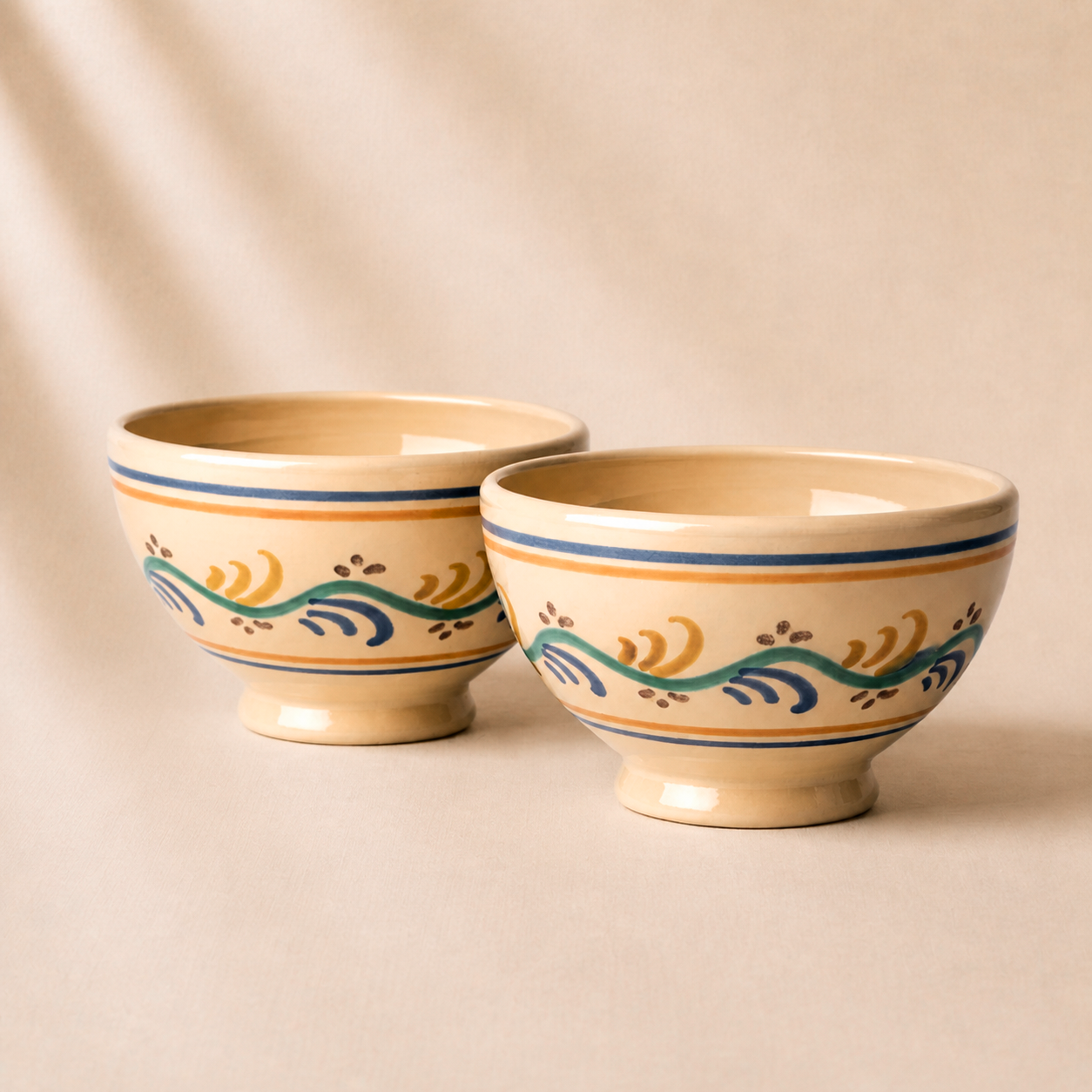 Two ceramic bowls with decorative patterns on a beige background