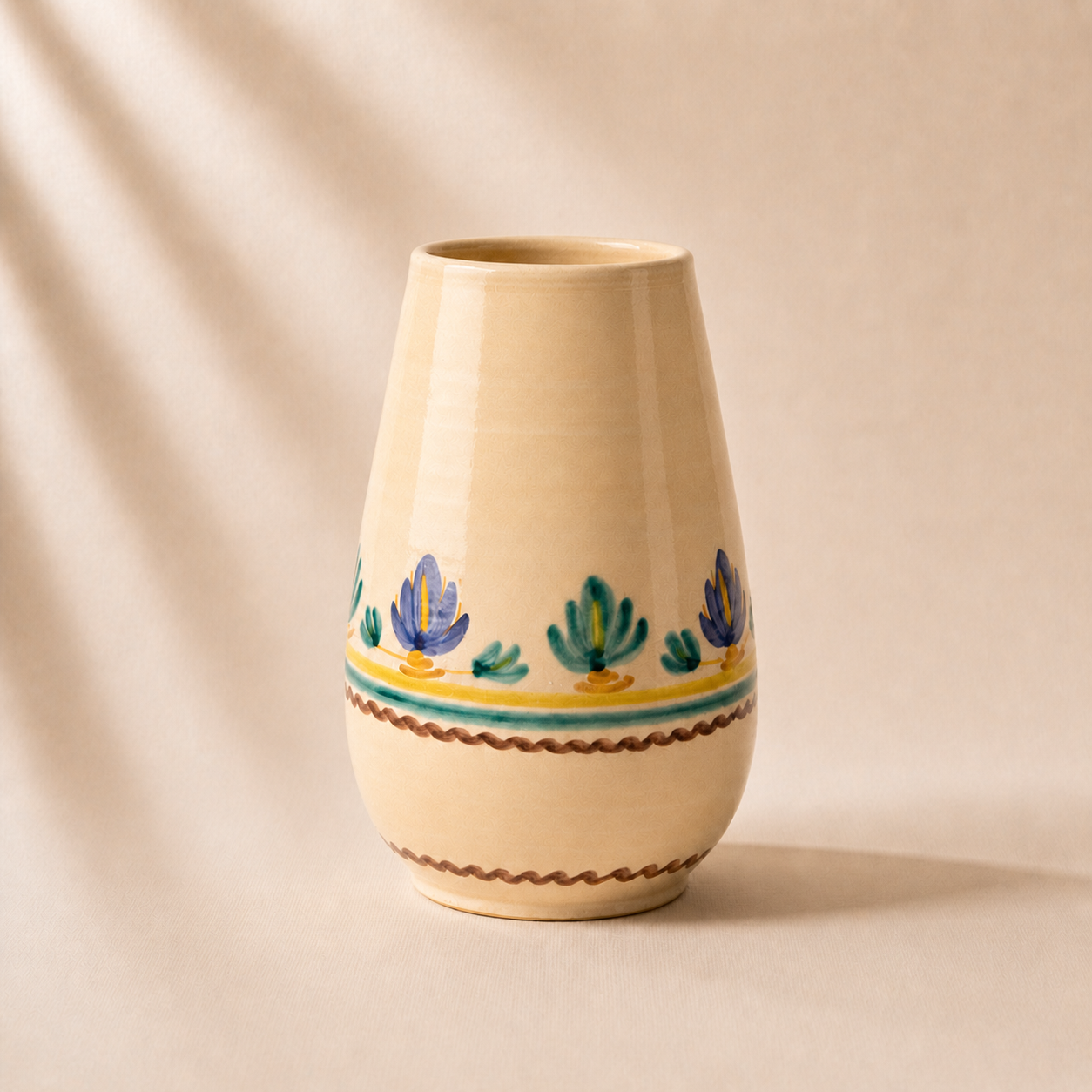Beige ceramic vase with decorative elements on a beige background