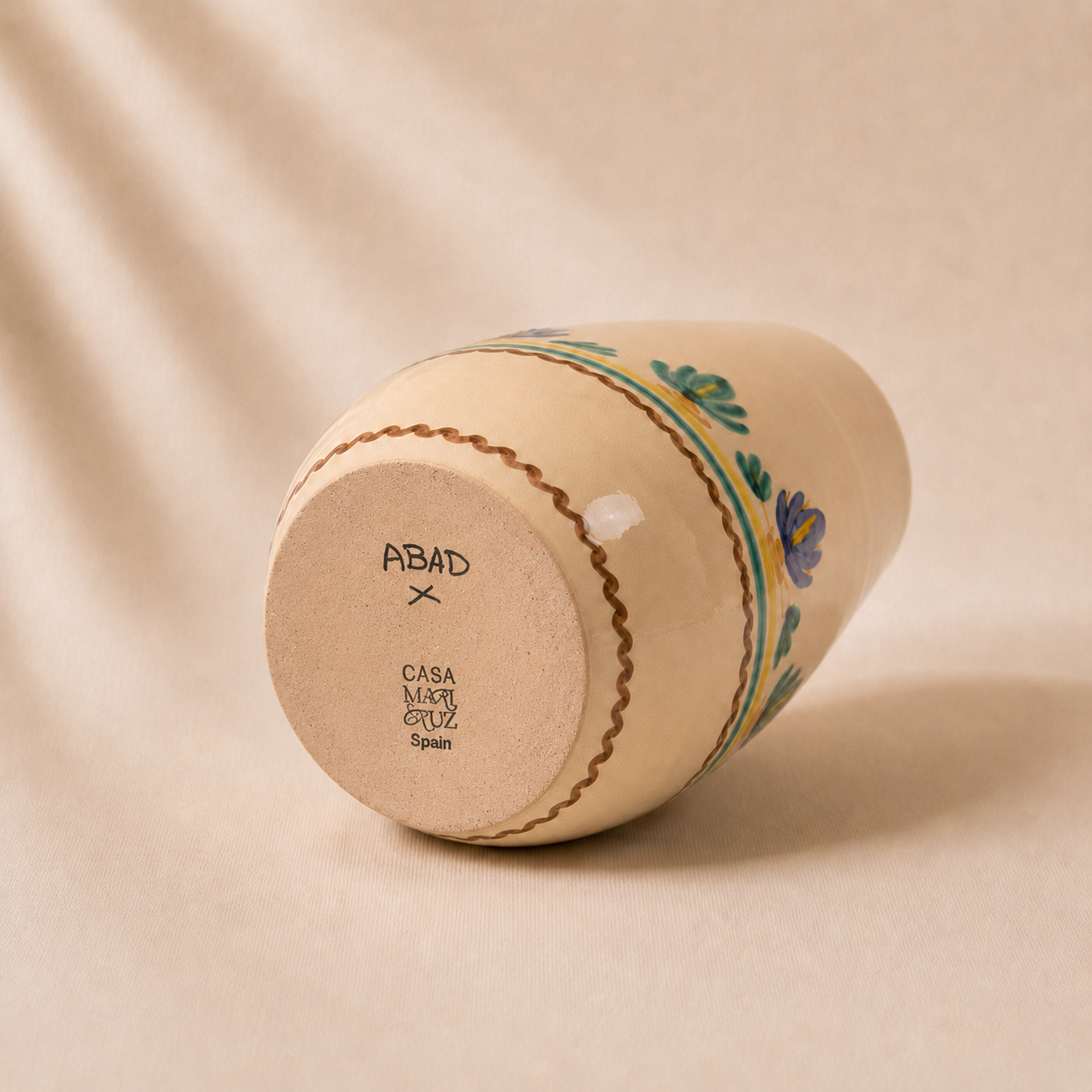 Ceramic container with floral design on a beige background