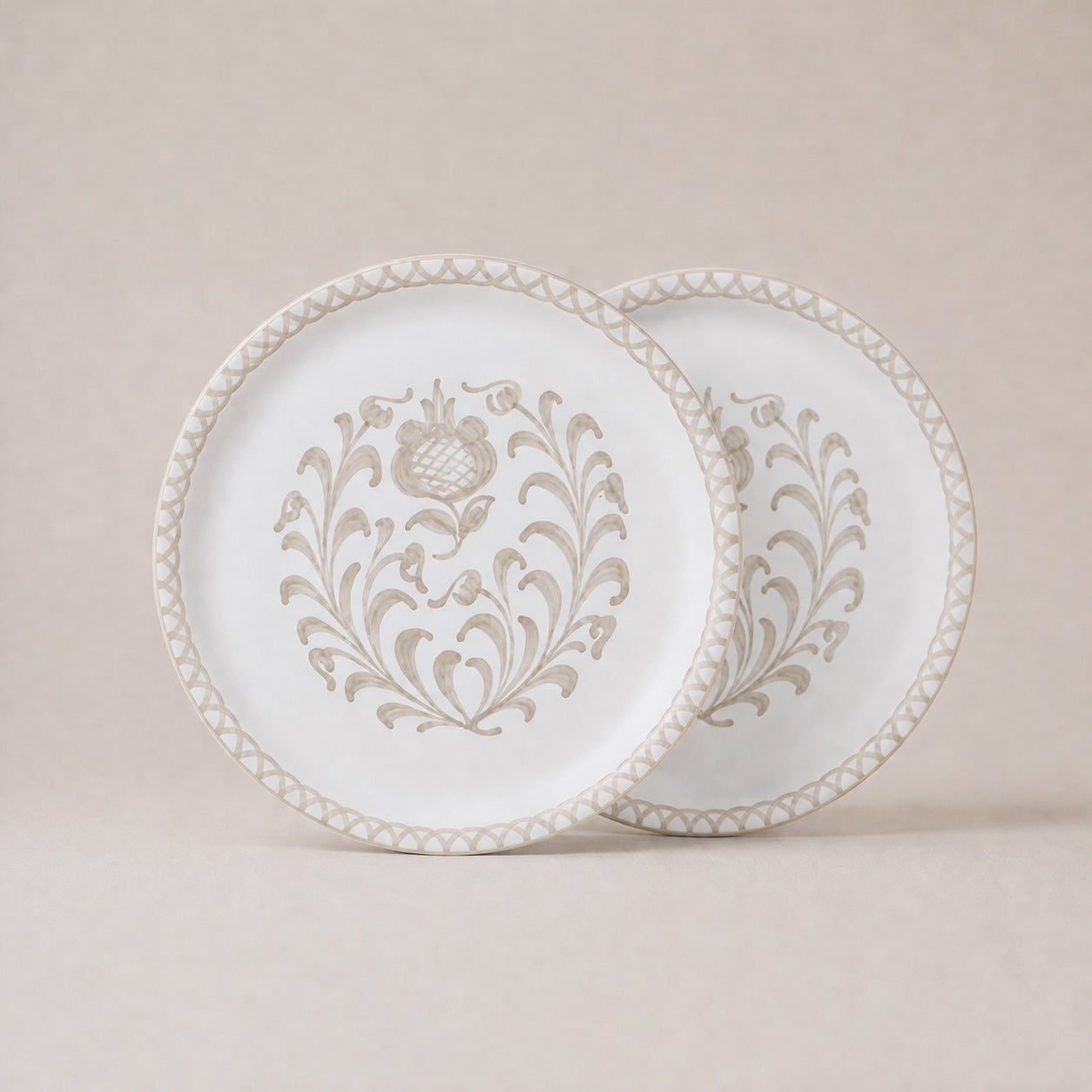 Two decorative plates with intricate patterns on a beige background