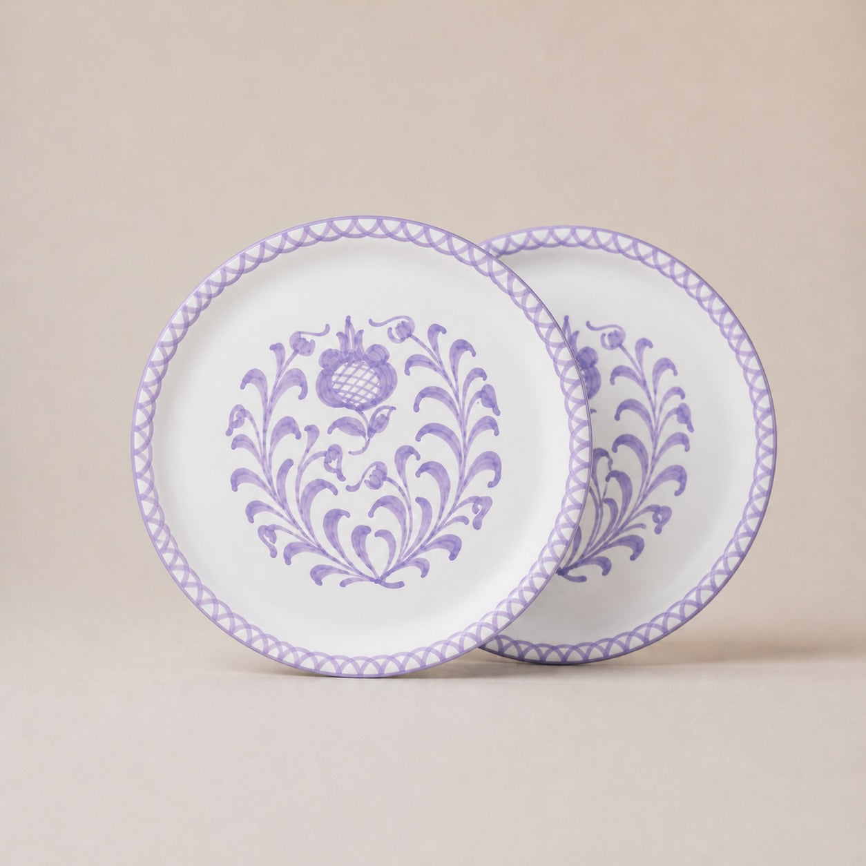 Two decorative plates with purple floral patterns on a beige background
