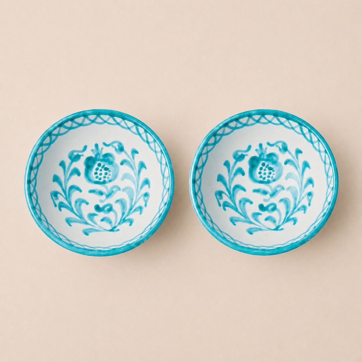 Two ceramic bowls with floral patterns on a beige background