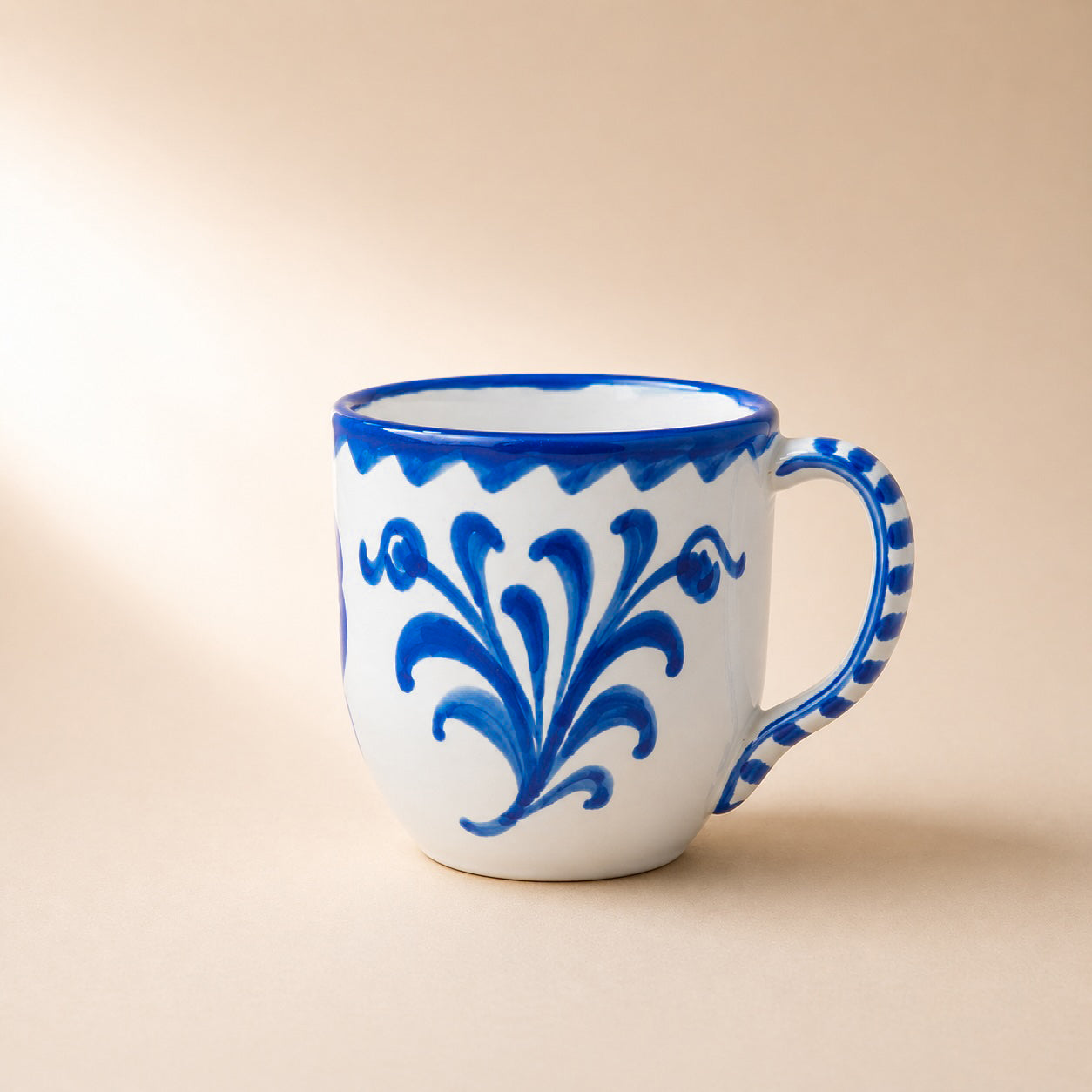 White mug with blue floral patterns on a beige background